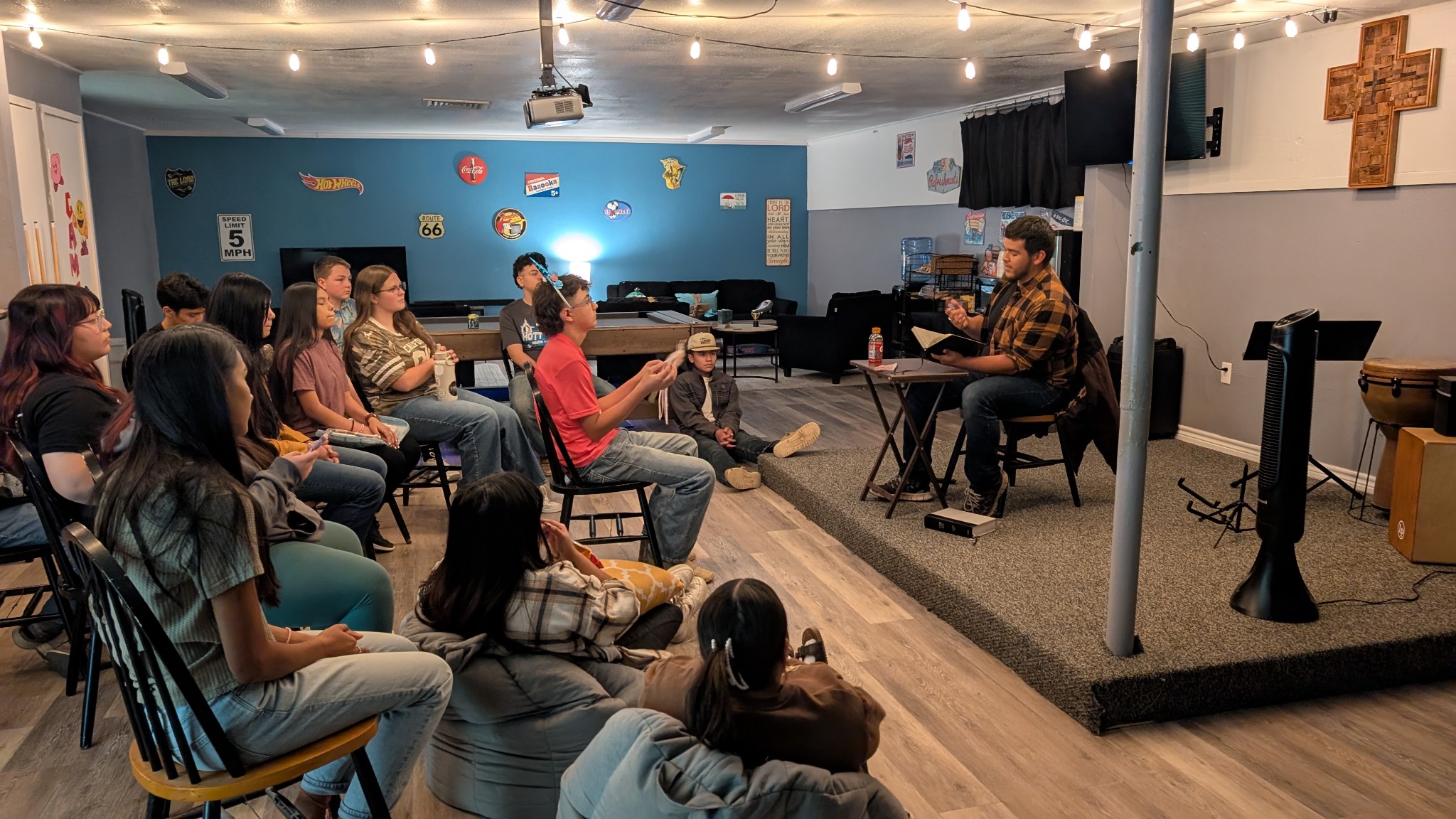 Students gathered around an open Bible during a lesson in the youth room